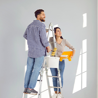 Happy couple painting their home with the help of a home improvement loan